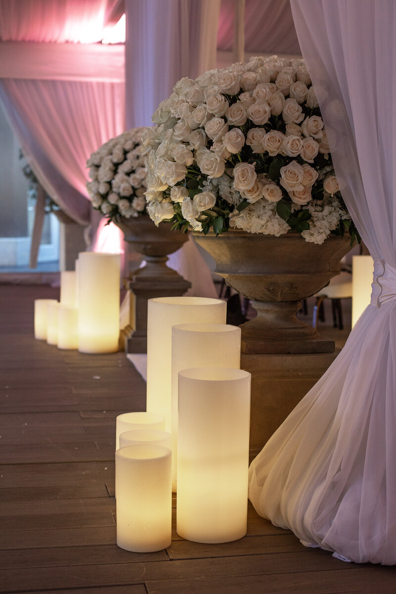 Large flameless candles at a wedding ceremony entrance